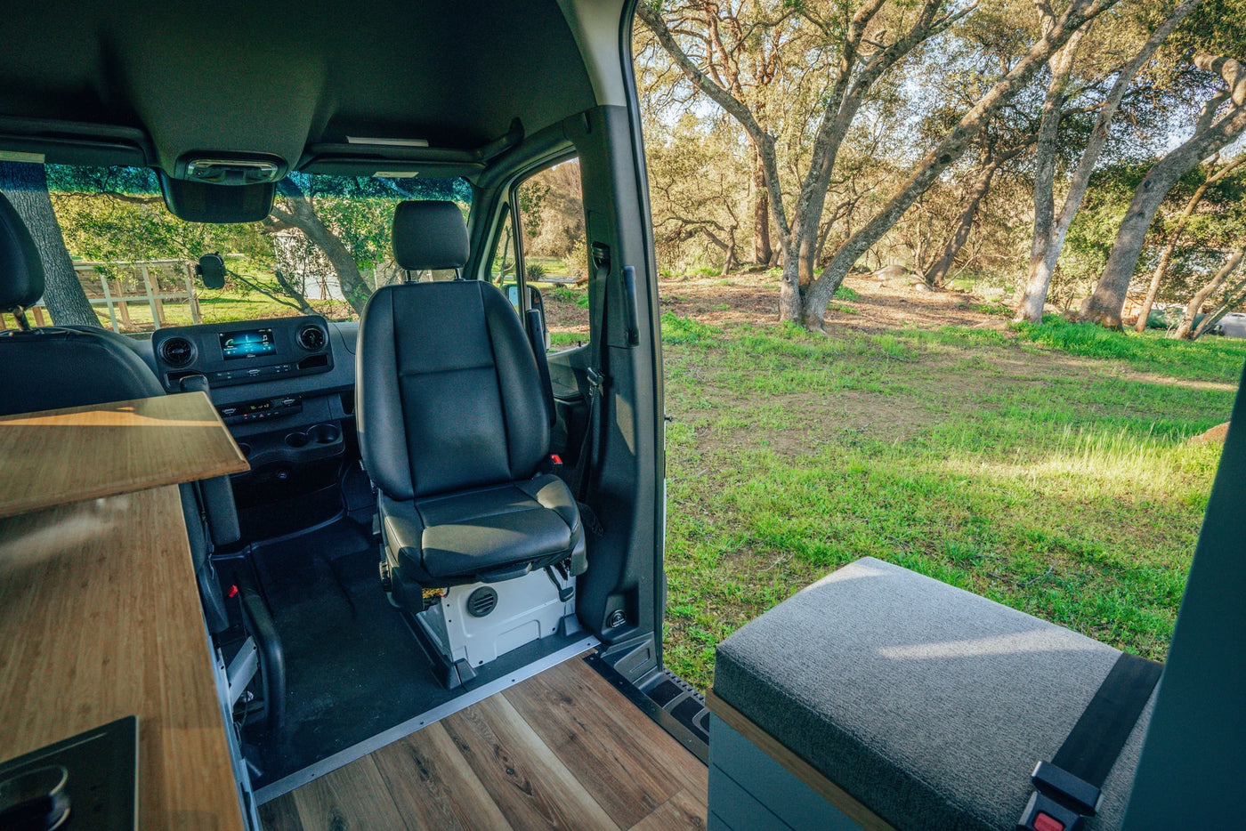  and stylish wood paneling.|Modern rv rental camper van interior: kitchen with stove — photo 10