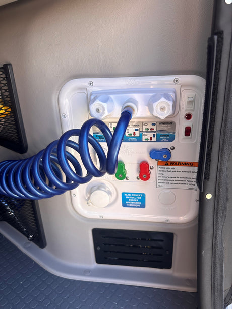 RV rental water management: Nautilus P4 system with blue coiled hose for filling, city water, and winterizing.