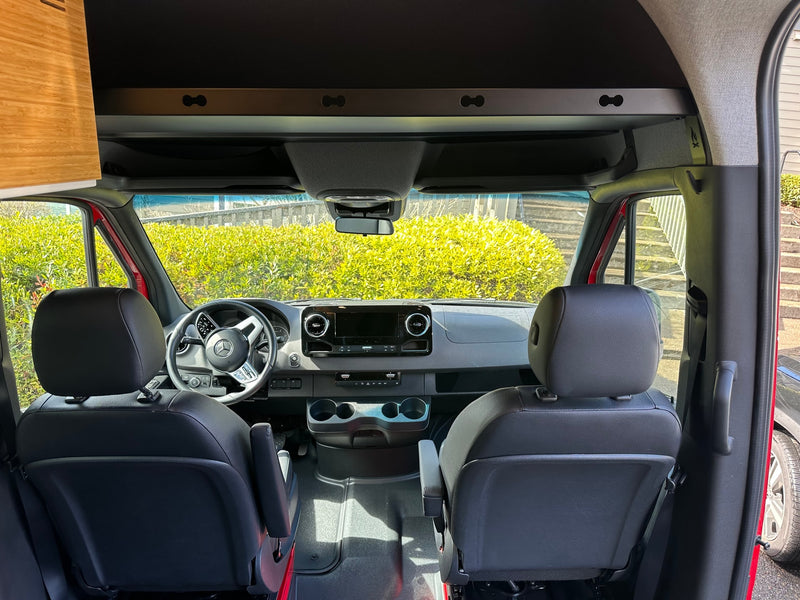 Front cabin of an RV rental, showing the modern dashboard, Mercedes steering wheel, and comfortable black seats. — photo 9