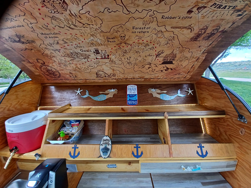 Explore adventure in this unique RV rental! Pirate map ceiling, kitchenette, & mermaid decor in a teardrop camper. — photo 3