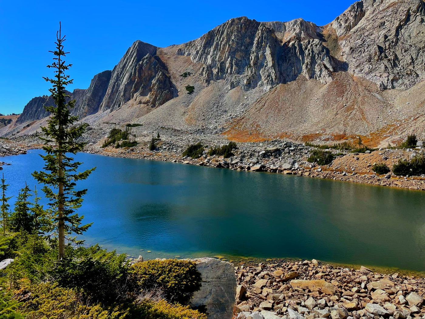 Serene mountain lake under clear blue sky, framed by rugged peaks. Perfect RV rental destination for nature & hiking adventures. — photo 13