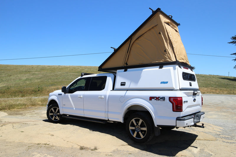 White Ford F-150 overland truck with a pop-top rooftop tent and camper shell, ready for your RV rental camping adventure. — photo 2