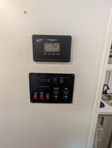 RV rental control panel. Solar controller, tank levels, water heater, water pump, and awning extend/retract switches.