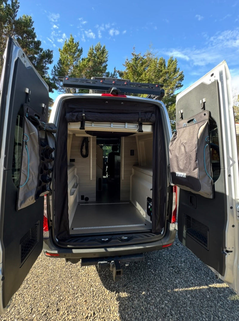  ready for adventure.|Explore nature in this adventure-ready RV rental! Silver camper van on a sunny dirt road by dry hillsides & a stream.|Silver camper van RV rental parked on a dirt site surrounded by tall evergreen trees. Ideal for forest camping.|Grey RV rental van with awning extended at a forest campsite — photo 2