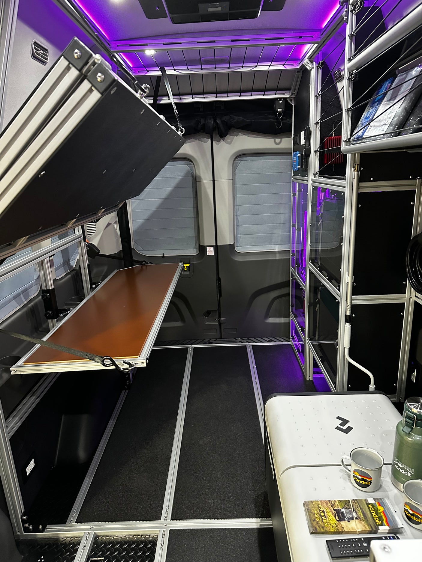 Spacious, modular Vandoit camper van interior, ideal for RV rental adventures, featuring a fold-down bed and storage.