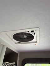 RV rental: Ceiling-mounted white vent fan with accessible speed/direction controls against a textured white ceiling.