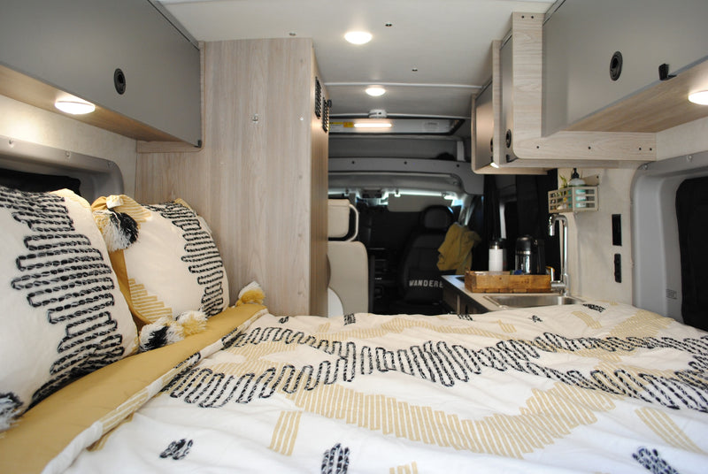  and a wooden serving tray. Front cab visible.|A light grey Winnebago Solis camper van — photo 6