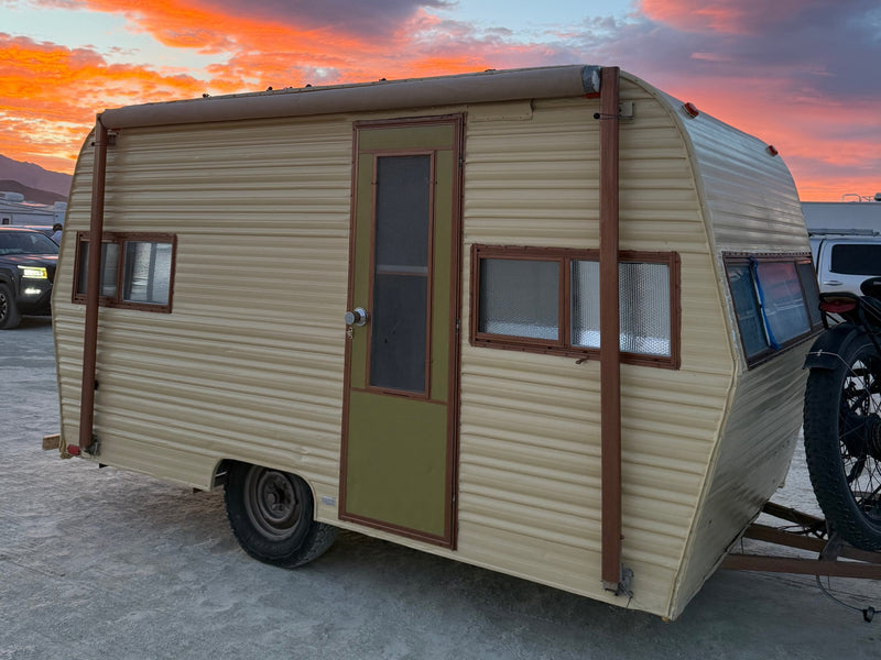  ready for your next adventure.|Vintage beige RV rental under a stunning desert sunset. This travel trailer features a green door — photo 2