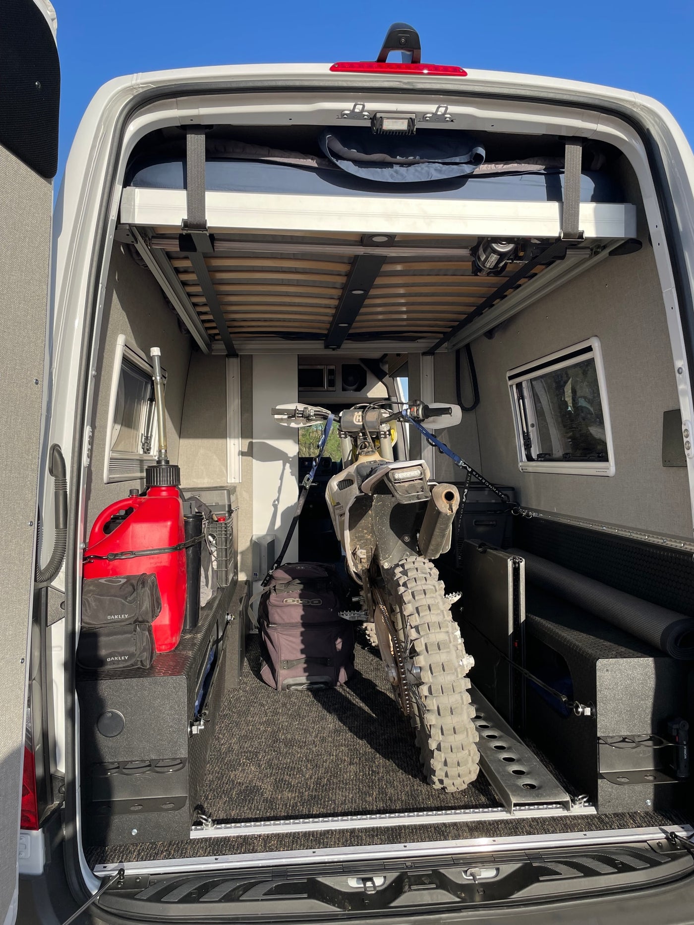  and a convertible sleeping area.|RV rental: Spacious camper van interior with an elevated bed — photo 8