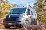 This stylish camper van, available for RV rental, offers the perfect van life adventure parked among pine trees.