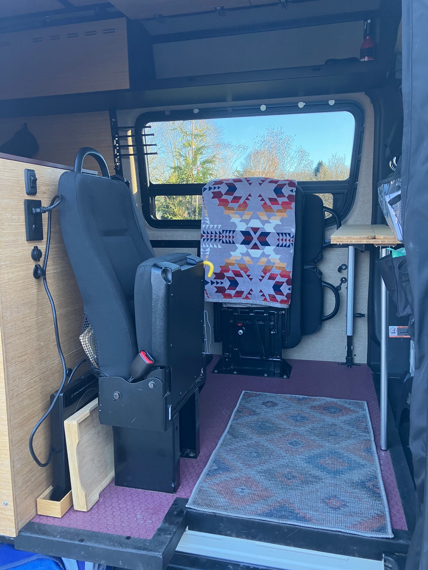 This inviting RV rental interior features versatile seating, a compact kitchen setup, and a dining area by the window.
