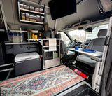 This cozy rv rental interior features clever storage, a fridge, kitchen setup, and a versatile Lagun table for comfortable travel.