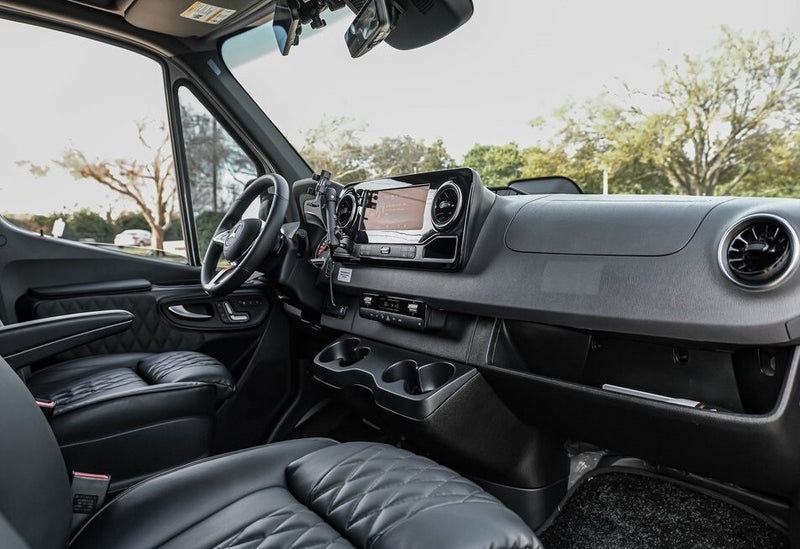 This rv rental van's interior showcases comfy black quilted seats, a modern Mercedes-Benz dashboard, and touchscreen for road trips. — photo 5