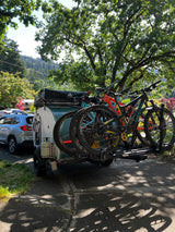 This RV rental teardrop camper hauls mountain bikes and a roof tent, ideal for outdoor adventures and camping.