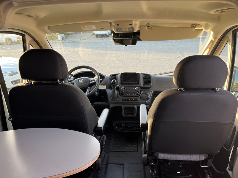 Inside an RV rental camper van: view of the dashboard, front seats, and a swiveling table on the left. — photo 7