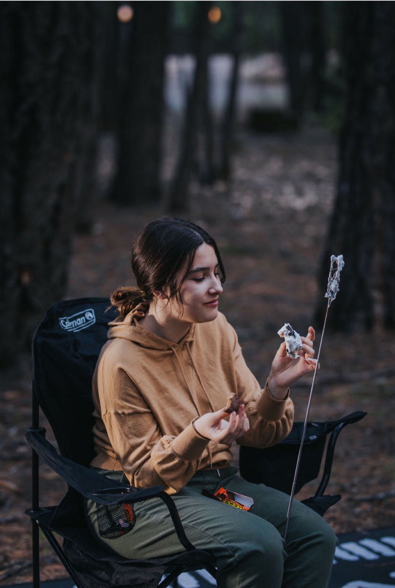  and a cooler under a canopy in the woods.|Four women share a picnic lunch at a checkered table in a wooded area — photo 16