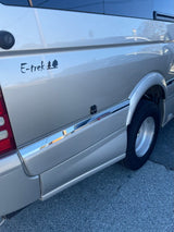 Close-up of an E-trek rv rental camper van's side with tree decal, ready for your next outdoor adventure.