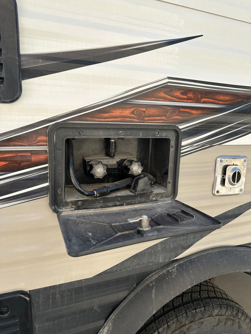 RV rental exterior: an open outdoor shower, water heater vent, and tire. Ideal for washing up while camping. — photo 12