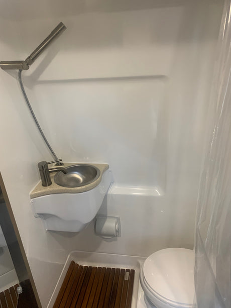 This RV rental features a practical wet bath, combining a shower, sink, and toilet in a compact space.