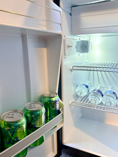 RV rental mini-fridge stocked with green La Croix cans and bottled water, ready for refreshing drinks on your adventure.