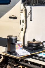 RV rental outdoor kitchen featuring a Keurig coffee maker, cooktop, and pan. Perfect for adventurers on the go.