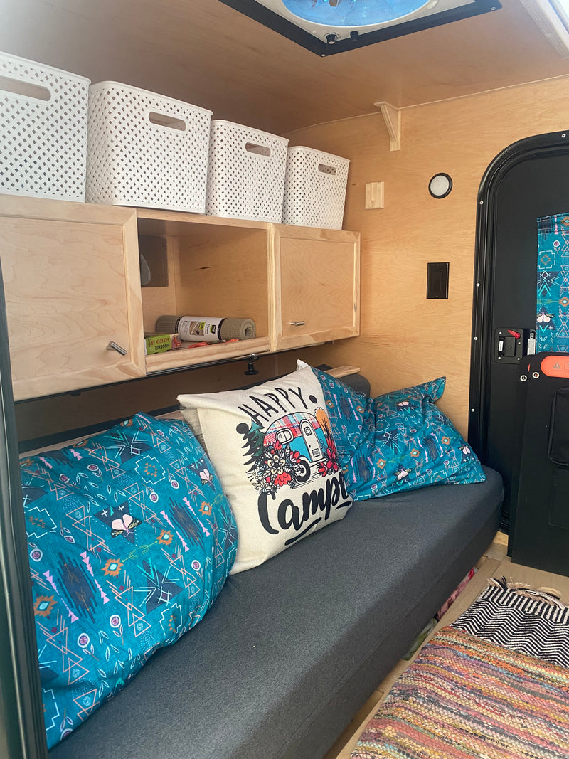 Enjoy a cozy RV rental experience! Organized camper interior with overhead storage, comfy seating, and decor pillows. — photo 7