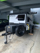 Gray Tigermoth compact off-road trailer with spare tire, hooked up & ready for your next RV rental adventure.