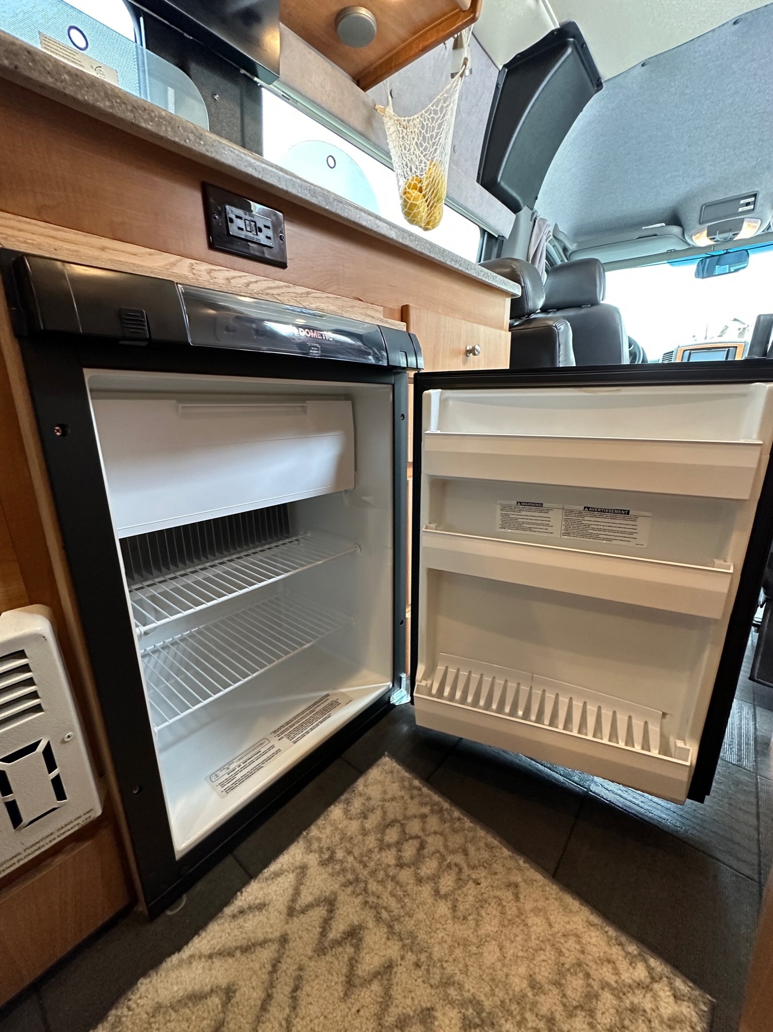 Interior of an RV rental: An open Dometic refrigerator/freezer with ample shelving, ready for your road trip adventures.