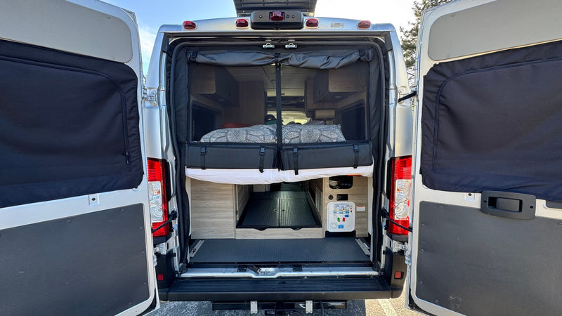  is parked at a sunny forested campground with other campers visible.|An RV rental camper van with a pop-top is parked at a scenic campground under tall — photo 6