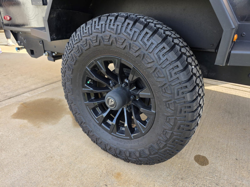 Close-up: Rugged black off-road tire & wheel on an RV rental trailer, ready for adventure trips. — photo 15