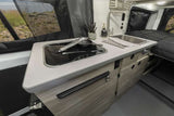 Spacious kitchen and cozy bed inside this modern RV rental, ready for scenic adventures.