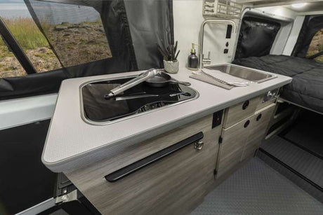 Spacious kitchen and cozy bed inside this modern RV rental, ready for scenic adventures.