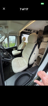 RV rental: Inside a camper van, showing cream-colored front seats, steering wheel, and overhead controls. Ready for your adventure!