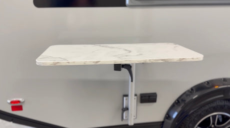 Convenient exterior folding table on an RV rental, perfect for camping and outdoor dining.
