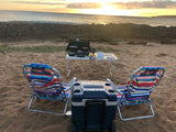 Relaxing beach sunset with an outdoor kitchen setup and chairs. Perfect for an RV rental escape!