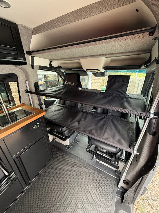  next to a comfy bed with a view of nature.|Inside this modern rv rental — photo 11