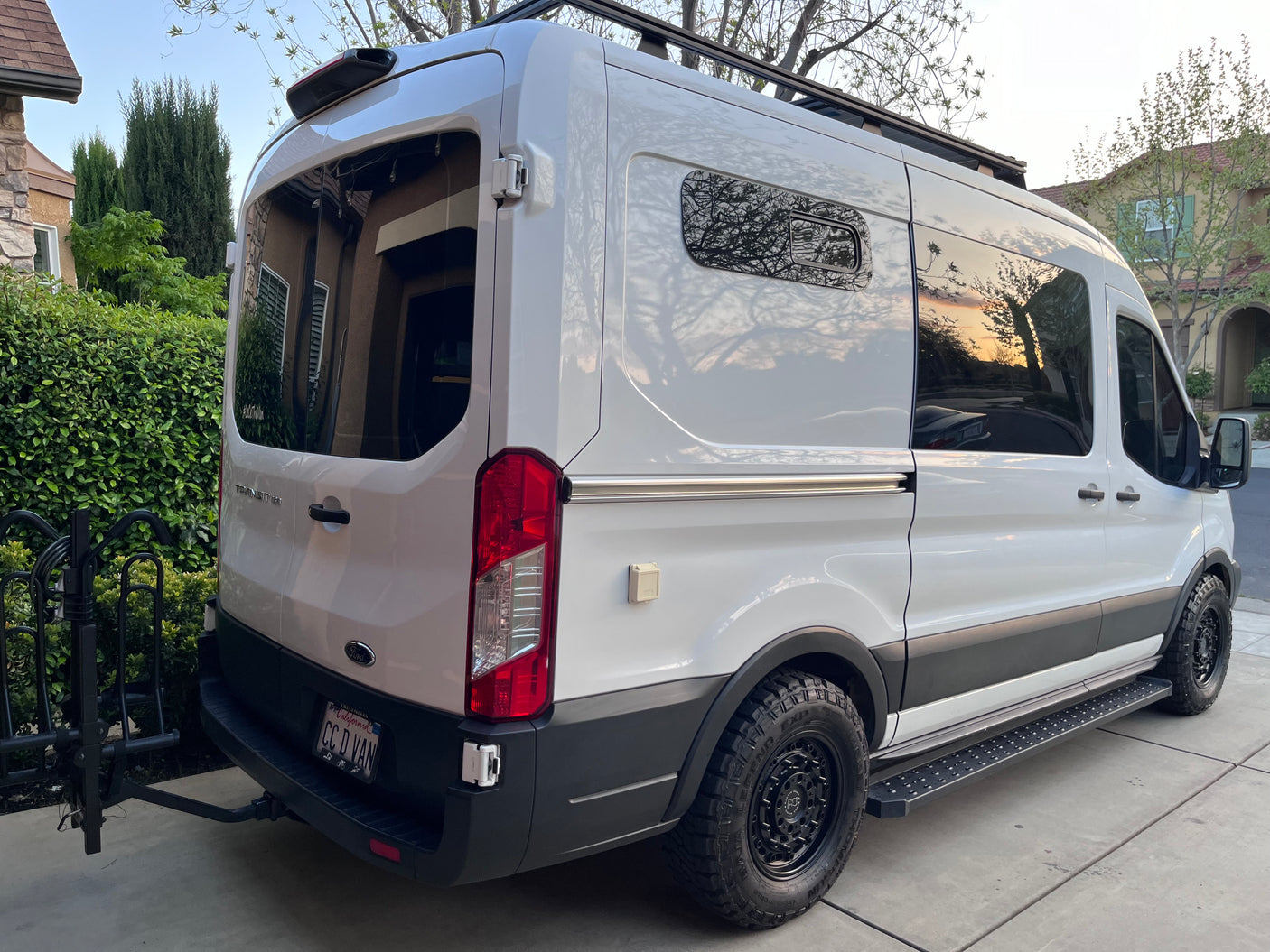 White Ford Transit camper van, an ideal RV rental. Equipped with roof rack & bike carrier for your next adventure.