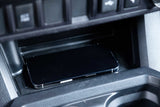 A smartphone rests in an RV rental's console charging tray, ready for your road trip adventures.