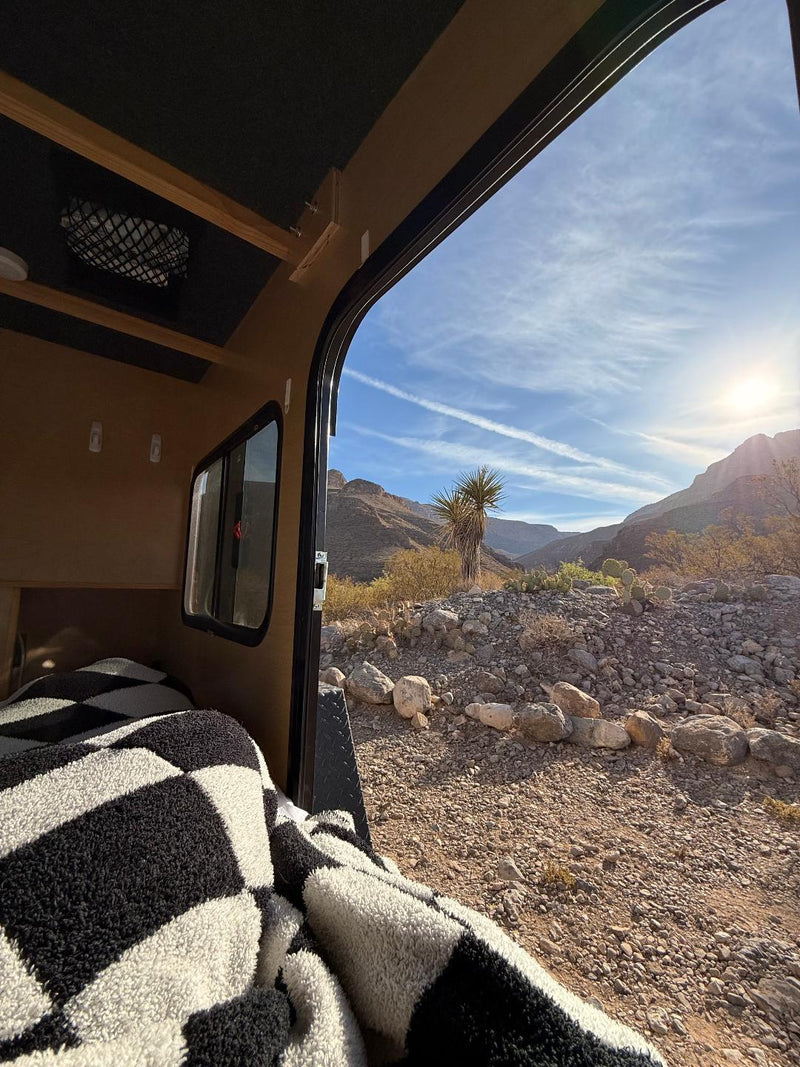  parked amidst mountains and large rocks for outdoor adventure.|Compact white Outbound Extreme travel trailer for rv rental — photo 9