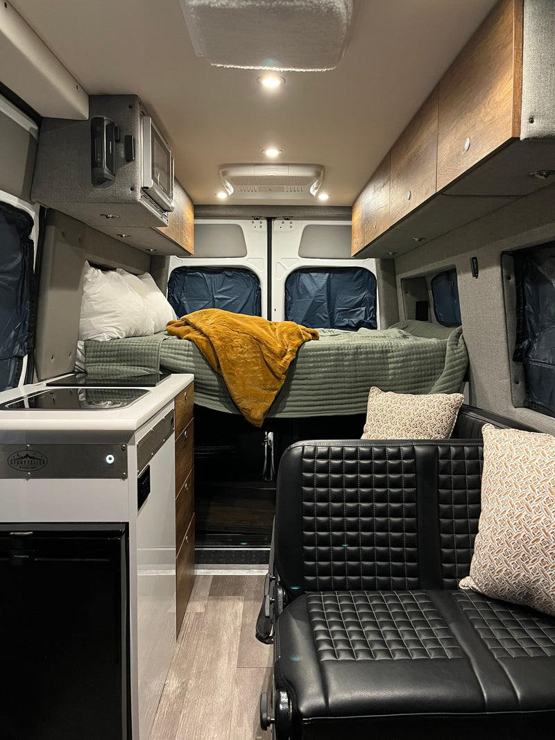 RV rental interior: cozy bed, compact kitchen, and comfy seating inside a modern camper van. — photo 21