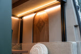 Cozy RV rental interior with warm LED lighting, comfortable seating, and a unique arched wooden panel featuring an etched mandala design.