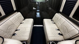 Luxurious RV rental interior with opposing cream quilted seats, dark paneling, and privacy blinds. Ideal for comfortable travel.