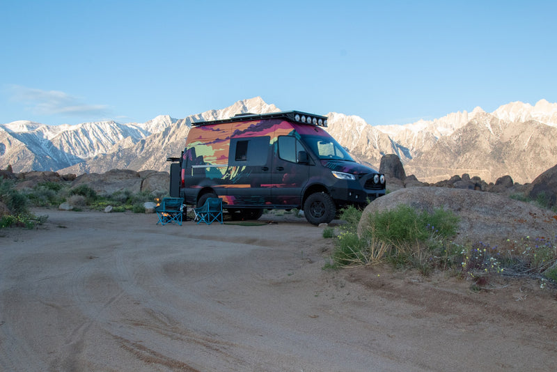  ready for your next adventure.|Colorful RV rental van with a custom wrap parked in a rocky desert — photo 4