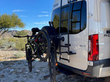 This rv rental Winnebago van, equipped with a rear bike rack holding two mountain bikes, is ready for outdoor adventures.