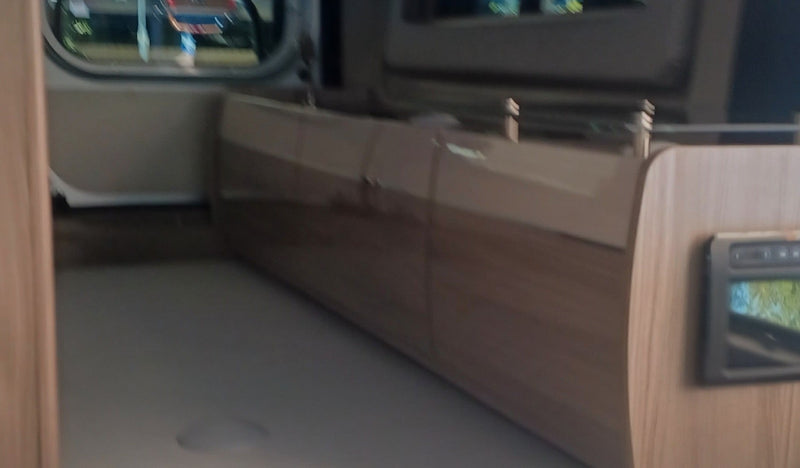  and gear shift.|This Thor RV rental interior features a comfortable sleeping area/sofa and a compact kitchen countertop with sink.|Comfortable light beige bed/seating in an RV rental — photo 15