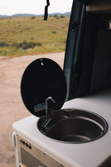 RV rental's compact sink and faucet unit, showing controls for awning/lights, ready for van life adventures.