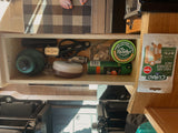 RV rental essentials: a well-organized drawer stocked with flashlights, bug repellent, first aid, and sewing supplies for travel readiness.