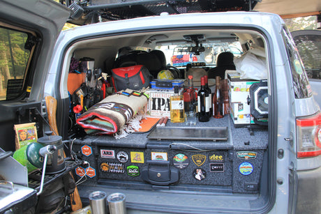 This organized RV rental features a well-equipped trunk with camping gear, a first aid kit, drinks, and cooking supplies for adventure.