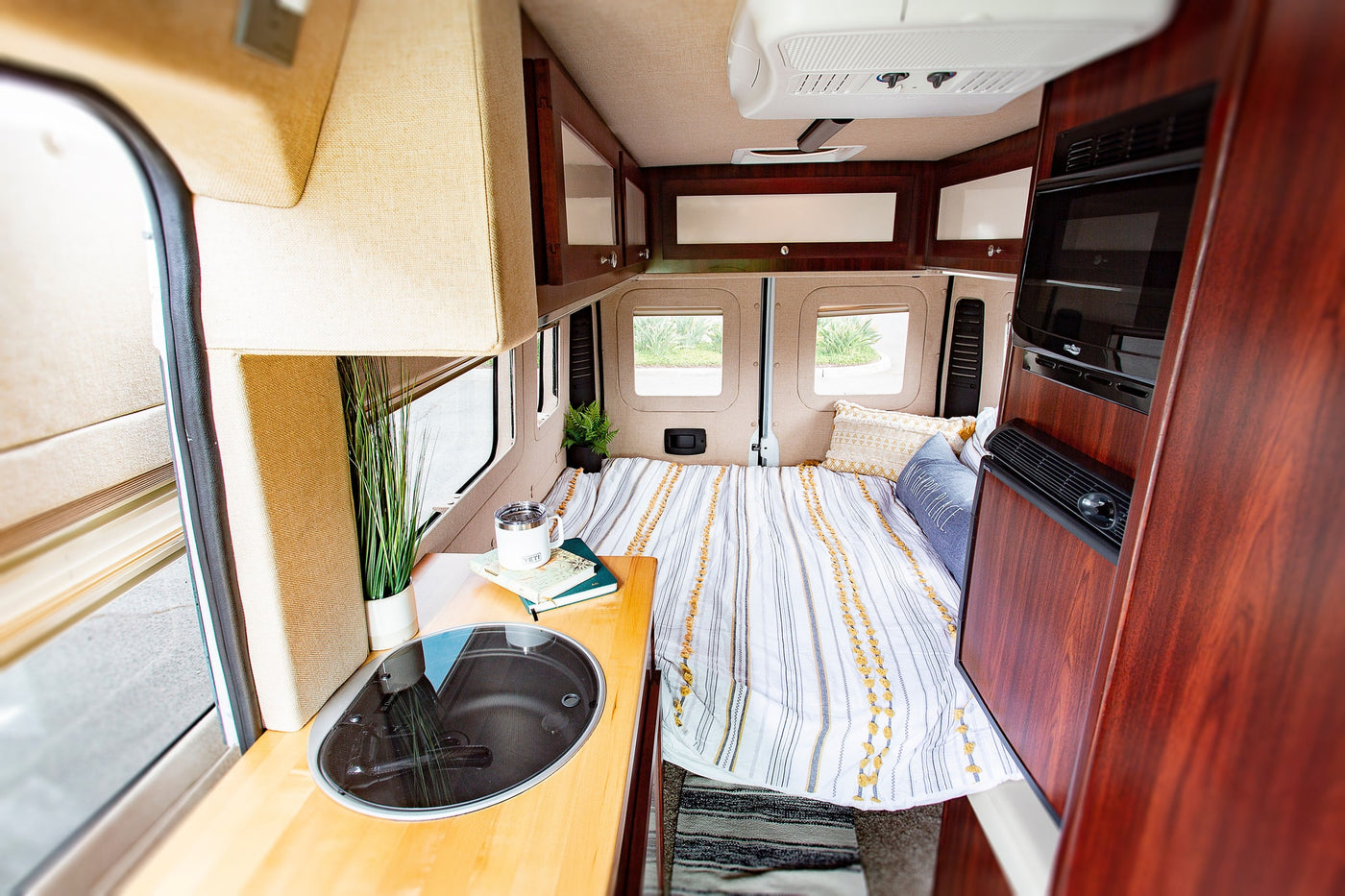  and comfortable carpeted living space.|RV rental: A white campervan with its side door open is parked at a campsite — photo 7