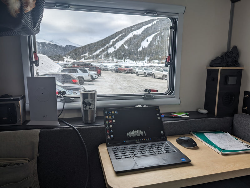 RV rental workspace at a snowy ski resort, with a laptop, Starlink, and mountain views from inside a camper. — photo 10